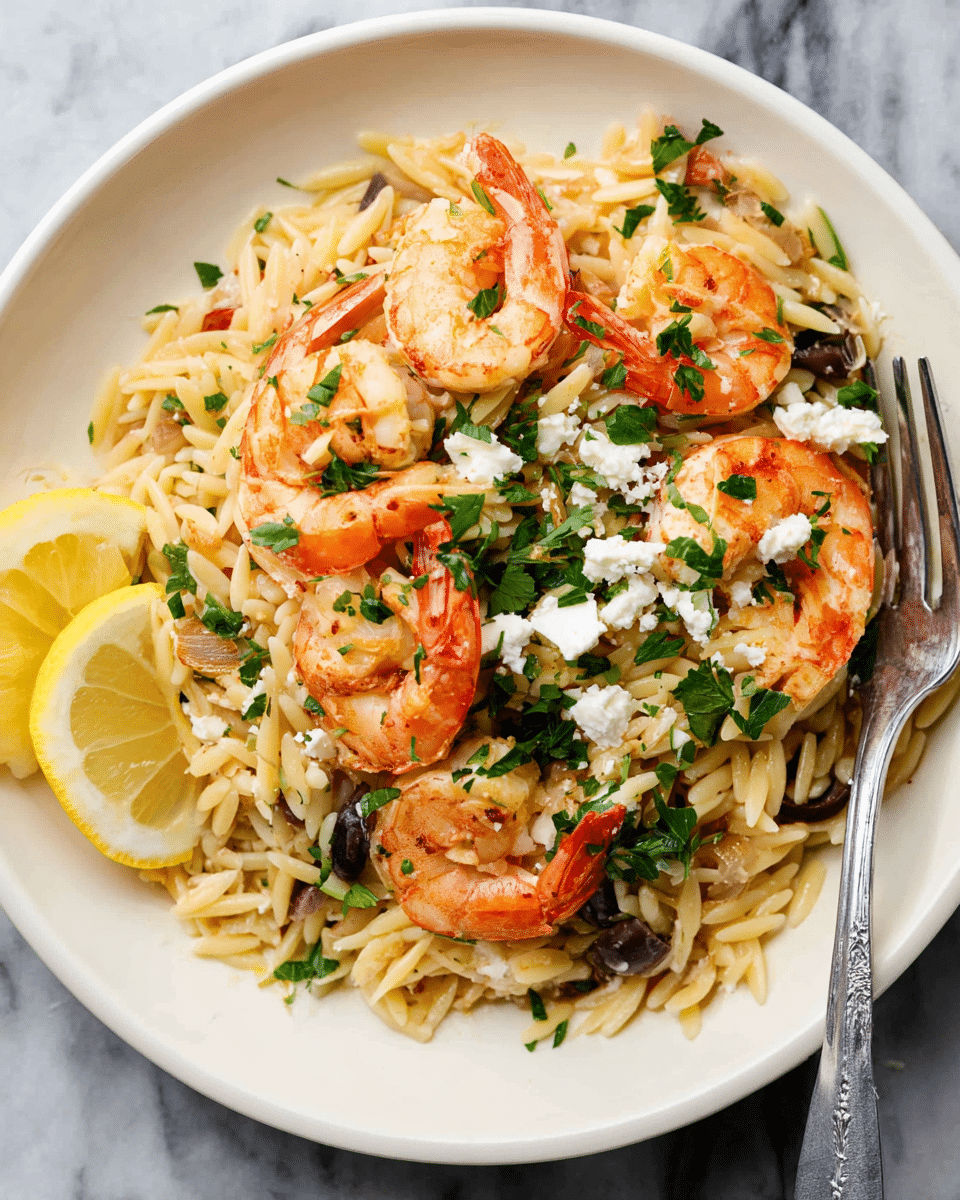 A white plate with a speckled design holds a dish with layers. The base layer is light yellow orzo pasta mixed with small pieces of cooked onion. On top are bright orange cooked shrimp scattered around, some partially covered by chopped deep green parsley. White crumbles of soft cheese are sprinkled on the shrimp and pasta. A few thin lemon slices with pale yellow skin and lighter yellow inside are placed near the edge of the plate. A silver fork rests on the side of the plate. The background shows a white marbled texture. Photo taken with an iphone --ar 4:5 --v 7