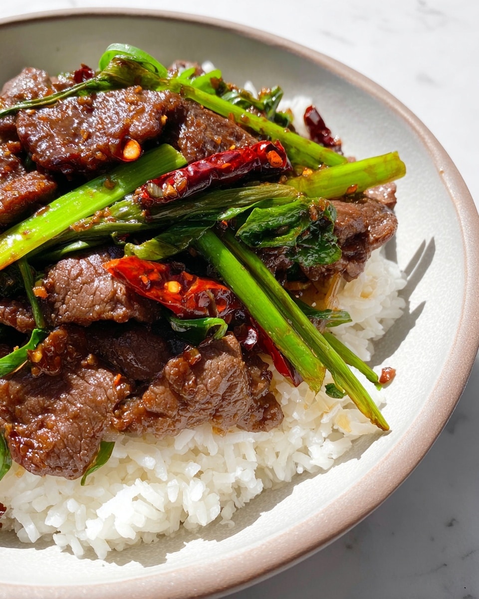A dish is shown with two layers on a white bowl: the bottom layer is white cooked rice with fluffy, separate grains; the top layer is a mix of cooked beef pieces that are brown and glossy, with bright green cooked scallions and dried red chili peppers scattered throughout, adding contrast. The beef has a slightly shiny texture indicating a sauce glaze. The white marbled background adds brightness to the photo taken with an iphone --ar 4:5 --v 7