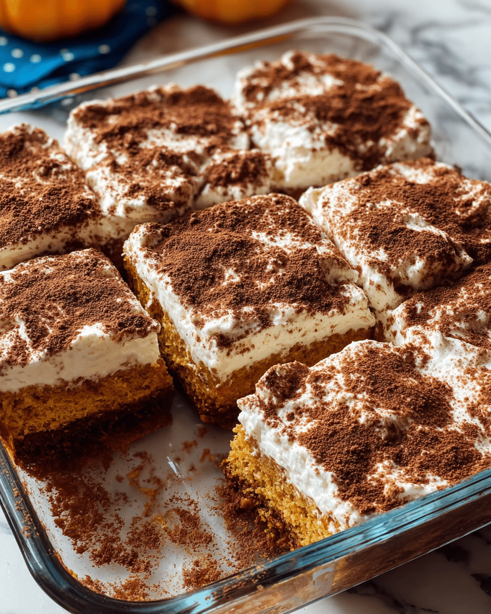 A square glass baking dish holds six thick, square pieces of a soft orange cake with a bumpy white cream topping. The cream is spread unevenly across the top of each piece, with a dusting of brown powder sprinkled generously over the cream, creating a contrast between the smooth white and the rough, dark brown textured surface. The pieces are closely set, with one piece missing, revealing the fluffy orange layer underneath and a bit of the dish’s bottom. The dish sits on a white marbled surface, with soft light highlighting the textures and layers. Photo taken with an iphone --ar 4:5 --v 7