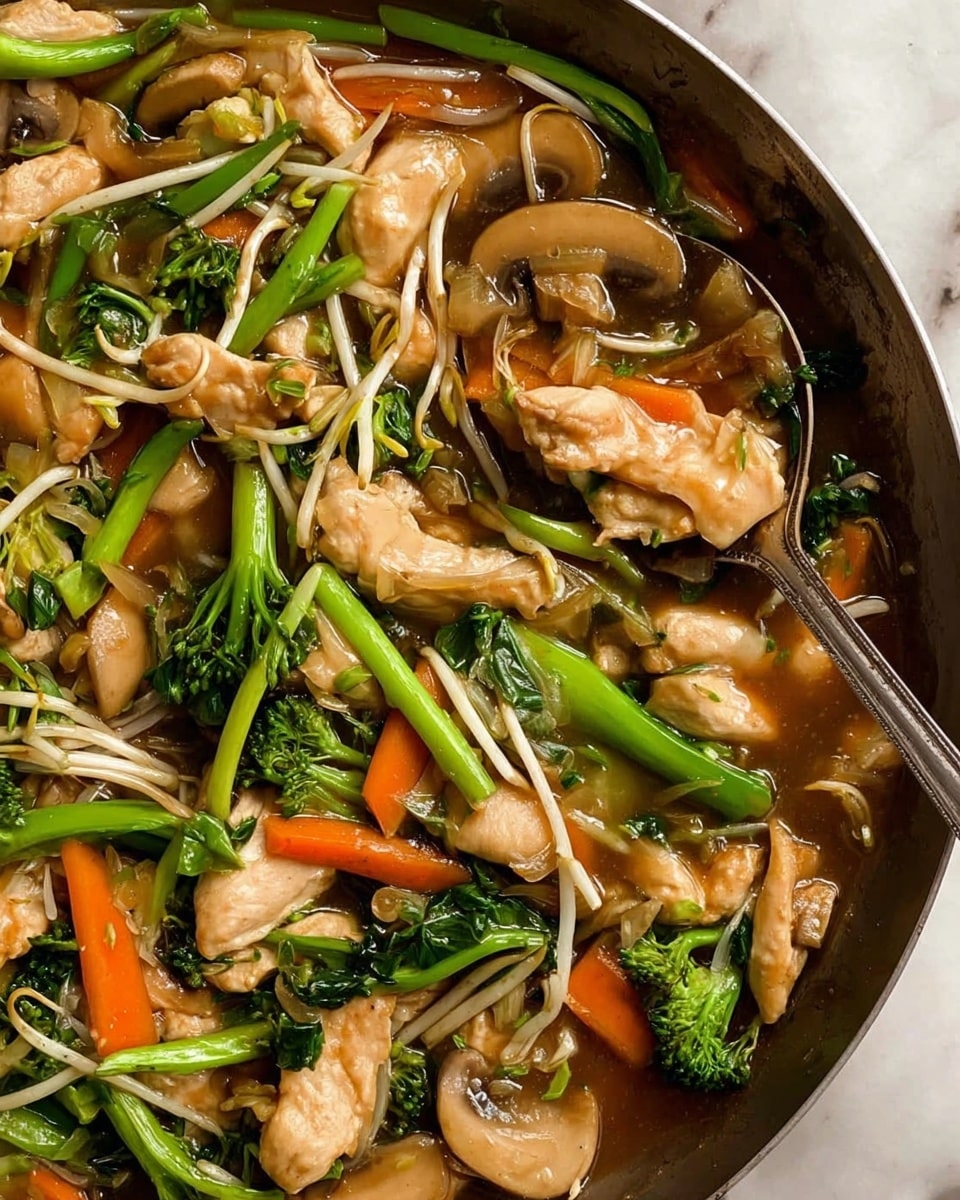 A close-up view of a stir-fry dish in a pan showing several layers: the top layer consists of light beige cooked chicken pieces with a slightly glossy texture, mixed with bright green stalks of broccoli or a similar green vegetable, orange carrot sticks, and light tan mushroom slices. Beneath these ingredients, there are thin white bean sprouts scattered throughout, all coated in a brown sauce that fills the bottom of the pan, giving a shiny and moist look. The background features a white marbled texture with a metal spoon partially visible, scooping some of the mix. photo taken with an iphone --ar 4:5 --v 7
