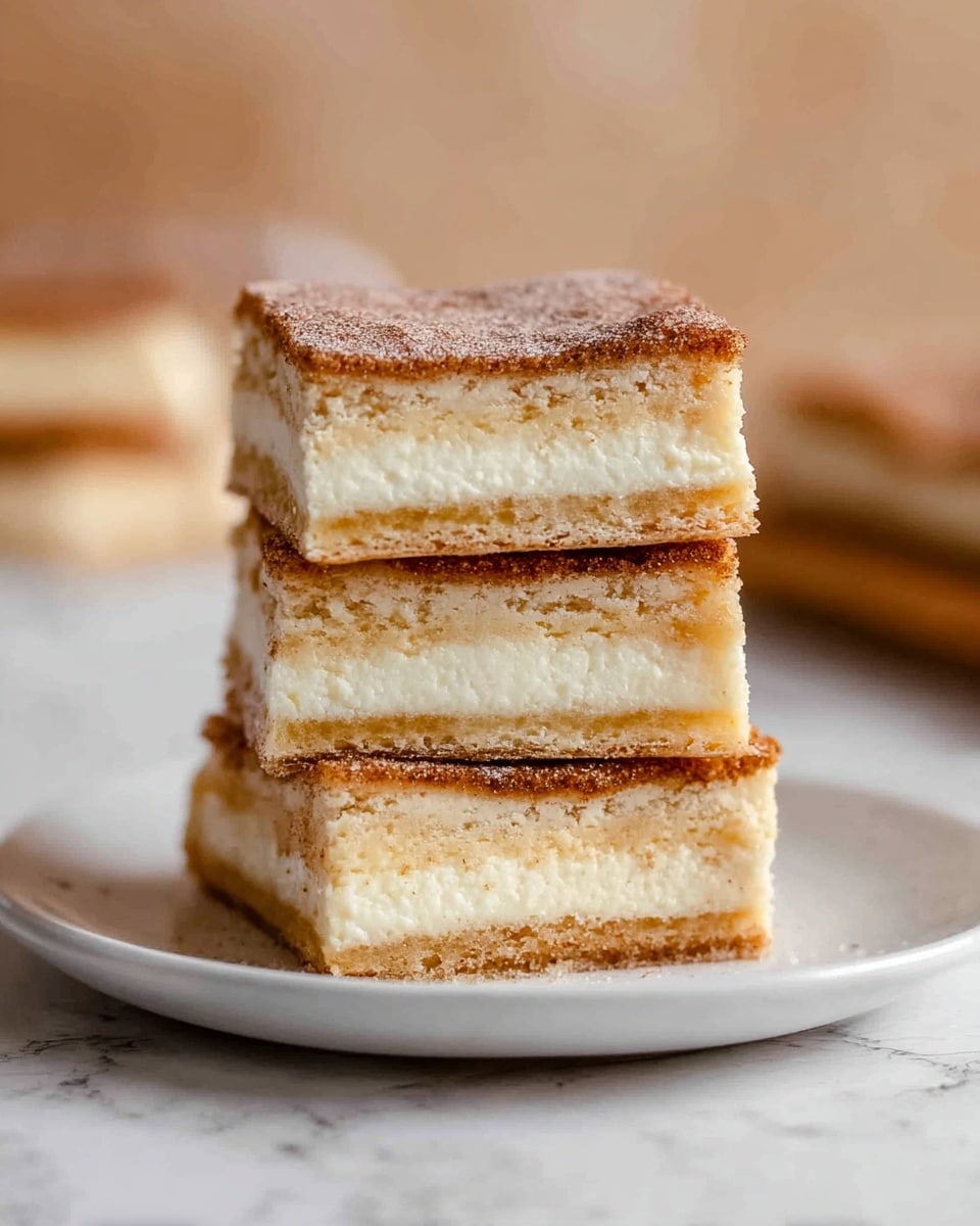 A stack of four square dessert bars is placed on a white plate on a white marbled surface. Each bar has three visible layers: a light brown, slightly crisp top layer with a dusting of fine sugar or cinnamon, a thick middle layer of creamy white filling, and a dense, golden-brown base with a firm texture. The bars are neatly stacked, showing the evenness of the filling and crust layers. The background is softly blurred with warm beige tones. photo taken with an iphone --ar 4:5 --v 7