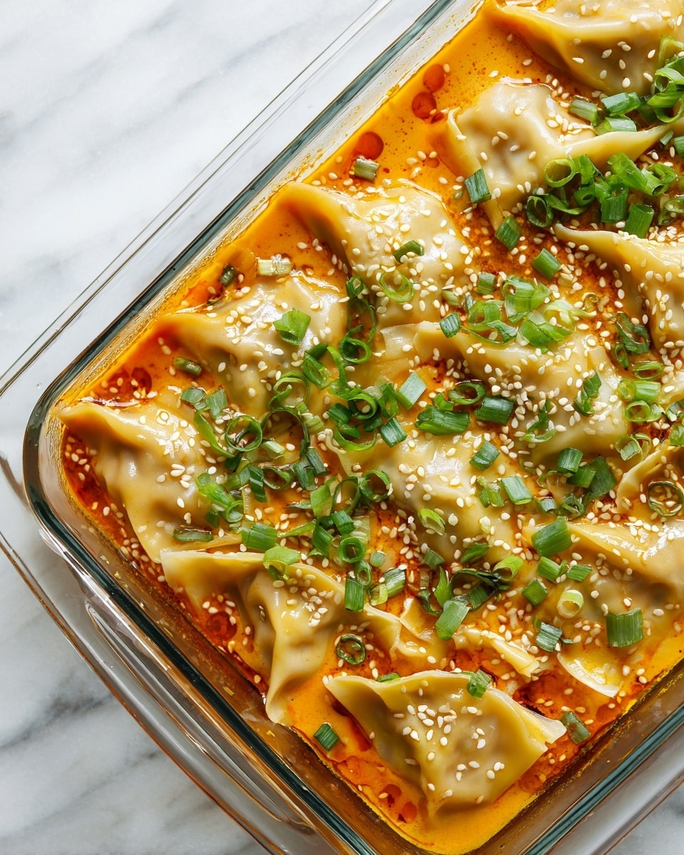 This close-up image shows a clear rectangular glass dish filled with dumplings in a rich, orange-colored sauce. There are about two layers visible: the bottom is the thick, creamy orange sauce with oil droplets floating on top, and the dumplings sit on the sauce in the upper layer. The dumplings are folded with smooth, slightly translucent light beige wrappers, some partially submerged in the sauce. The dish is topped with white sesame seeds and chopped fresh green onions scattered evenly, adding a pop of green and white texture. The whole scene is placed on a white marbled surface. photo taken with an iphone --ar 4:5 --v 7
