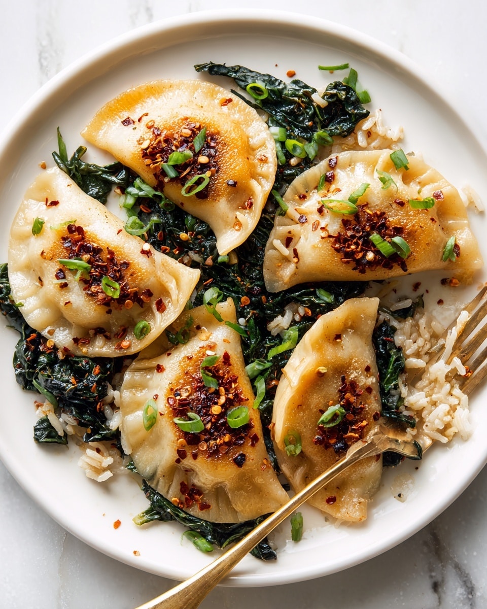 A white plate with four golden brown dumplings arranged in a circle, each dumpling topped with dark red chili flakes and chopped green onions. Underneath the dumplings are wilted dark green leafy vegetables, and scattered around the plate are some white and brown rice grains mixed together. A gold fork is placed on the right side with some rice on it, resting partially under one dumpling. The background is a white marbled texture. Photo taken with an iphone --ar 4:5 --v 7