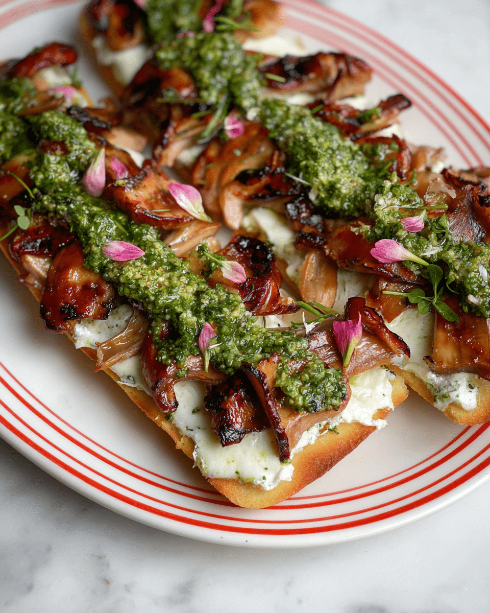 The image shows two long slices of toasted flatbread placed on a white plate with red stripes. Each slice has a base layer of creamy white cheese spread evenly across the bread, followed by a layer of grilled, caramelized mushroom pieces that have a rich brown color with shiny, slightly charred edges. On top of the mushrooms, there is a green herby pesto sauce spread in a strip down the middle. Small pink flower petals and green herb leaves are sprinkled on the pesto, adding delicate color and texture details. The plate sits on a white marbled surface. photo taken with an iphone --ar 4:5 --v 7