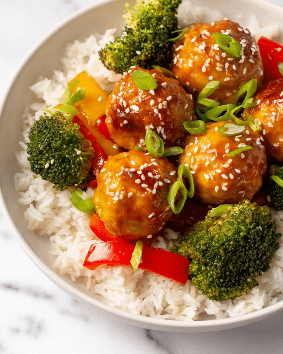 A white bowl holds a serving of white rice as the base layer, topped with bright green roasted broccoli and thin strips of red bell pepper arranged around the edges, adding color contrast. Four glossy, golden-brown meatballs coated in a shiny sauce sit in the center, sprinkled with white sesame seeds and garnished with small pieces of chopped green onion. A pair of light brown wooden chopsticks rests over the top edge of the bowl. The bowl is placed on a white marbled textured surface. photo taken with an iphone --ar 4:5 --v 7