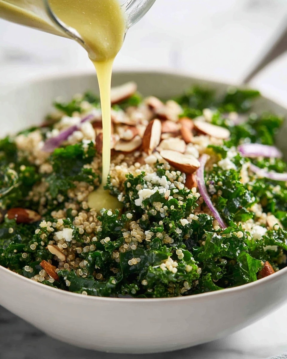 A close-up view of a fresh salad served in a white bowl, placed on a white marbled surface. The salad has three main visible layers: a base of small, light beige quinoa grains with a slightly fluffy texture, mixed with bright green kale leaves that have a rough, curly texture spread evenly throughout, and topped with small white crumbled cheese pieces along with roughly chopped brown nuts scattered on top, adding crunchy texture and varied color. The overall look is vibrant with green, beige, white, and brown tones blending naturally. photo taken with an iphone --ar 4:5 --v 7