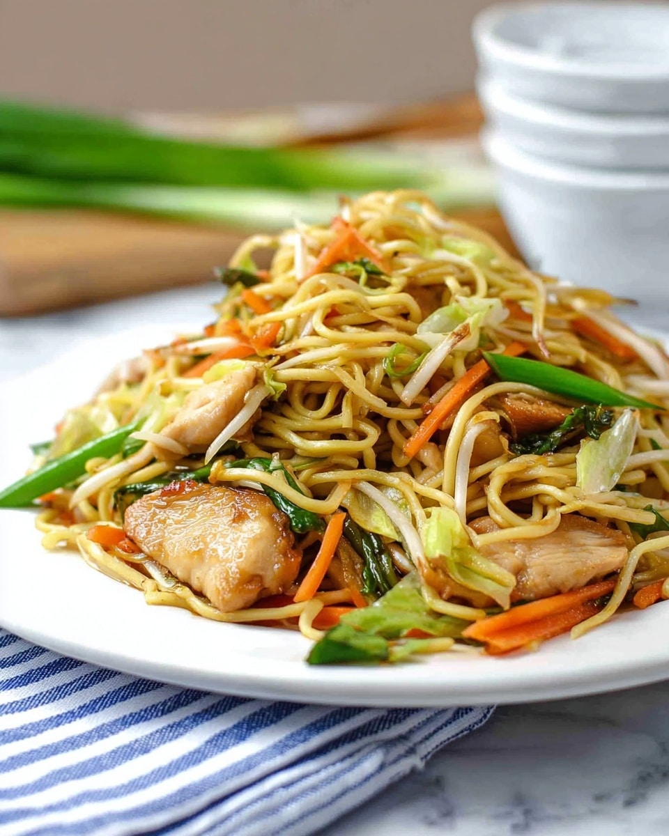 A white plate holds a dish of stir-fried noodles mixed with several layers. The bottom layer is thin, pale yellow noodles tangled together. On top, there are pieces of golden-brown cooked chicken with a slightly shiny texture. The dish also has bright green long strips of green onion and crunchy orange carrot sticks scattered around. The plate sits on a white marbled surface with a blue and white striped cloth partially under it. In the background, there are two stacked white bowls and some green onions blurred out. The overall look is fresh and colorful, with a mix of soft noodles and crisp vegetables. photo taken with an iphone --ar 4:5 --v 7